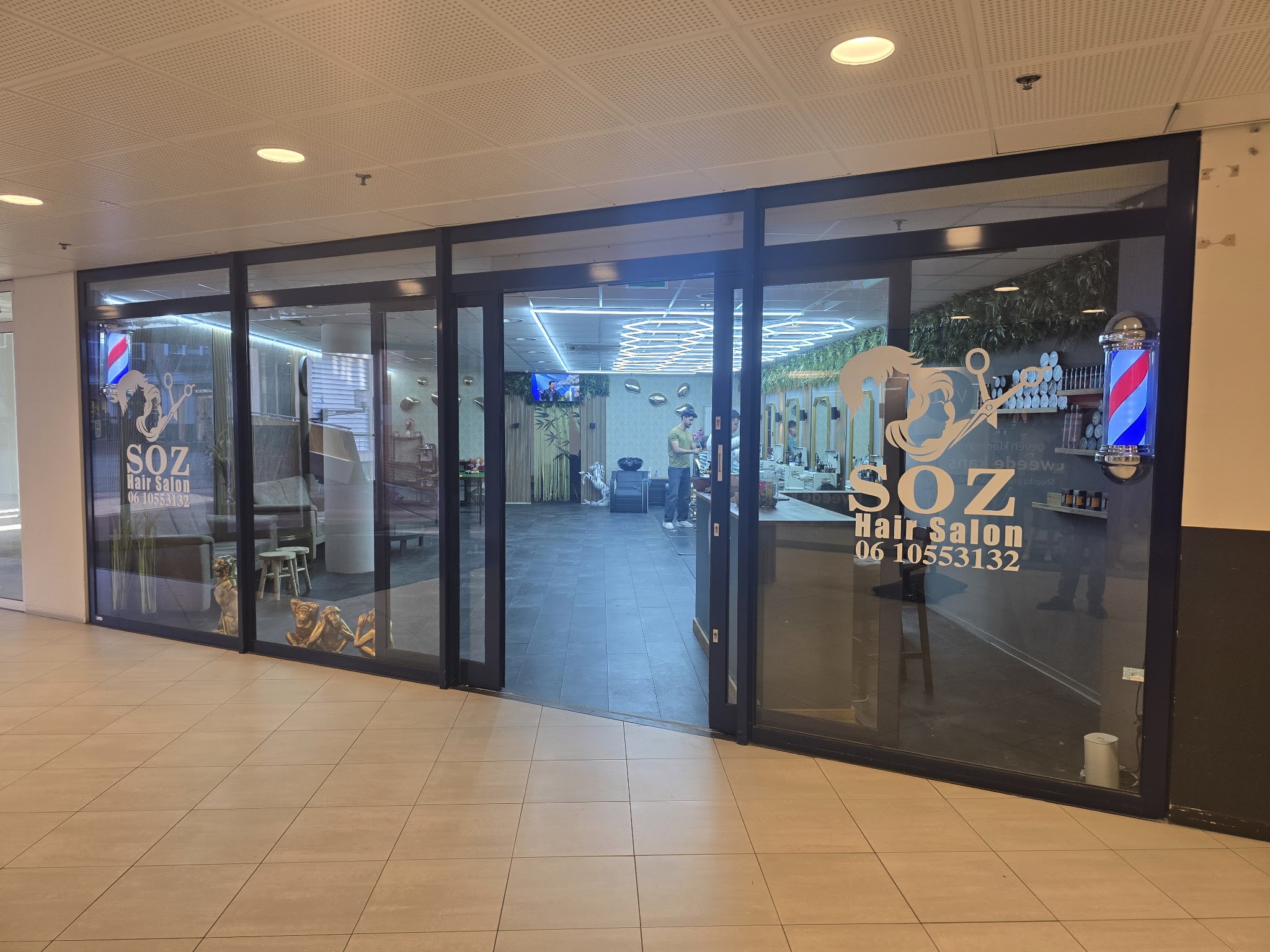De glazen pui van SOZ Hairstylers in Stadsplein Shopping Center, met het SOZ-logo op het raam en een kapperspaal